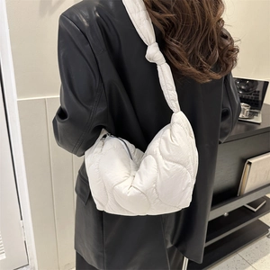 Borsa a spalla trapuntata bianca con elegante dettaglio a nodo indossata da una modella