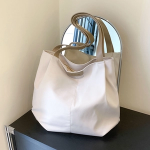 Minimalist beige canvas tote bag with brown handles in a modern home setting
