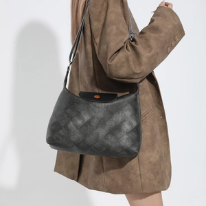 Schwarze gesteppte Tragetasche im Vintage-Stil mit Ethno-Gurt an einem Frauenmodell