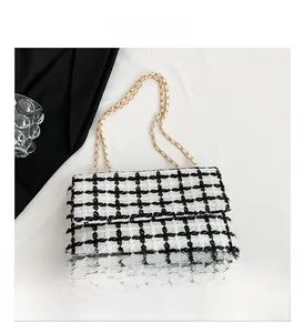 Détail du sac à bandoulière en tweed à carreaux noir et blanc avec chaîne dorée chic
