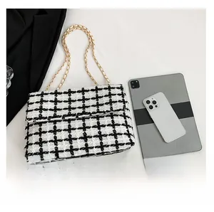 Vue détaillée du sac en tweed à carreaux noir et blanc avec bandoulière chaîne dorée et tablette