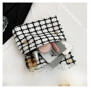 Détail intérieur d'un sac en tweed à carreaux montrant sa grande capacité de rangement