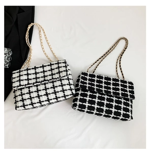 Détail de la texture en tweed à carreaux et de la bandoulière dorée des sacs à main