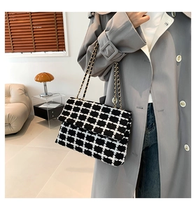 Vue détaillée du sac à bandoulière en tweed noir et blanc avec bandoulière chaîne