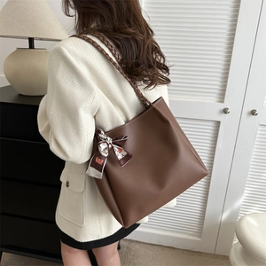 Brown woven strap tote bag with decorative silk scarf and spacious interior design