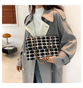 Détail d'un sac bandoulière en tweed noir et blanc vintage avec chaîne en métal doré