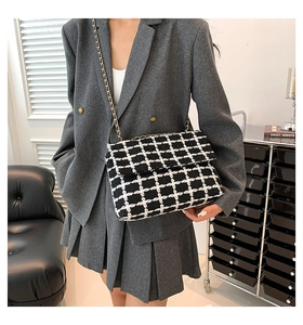 Sac à bandoulière en tweed noir et blanc porté avec une veste blazer grise chic