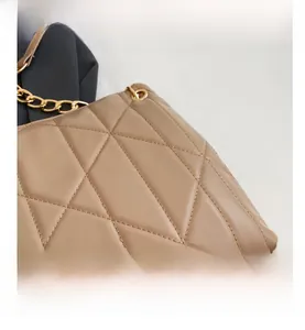 Detail showing khaki quilted leather texture and elegant gold metal chain of the handbag