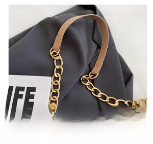 Detail of khaki quilted PU bag featuring golden chain and soft leather handle