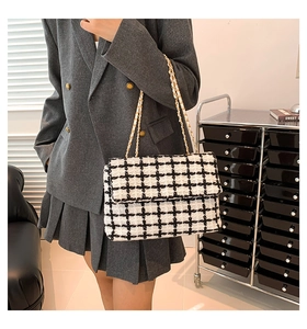 Gros plan sur la texture tweed noir et blanc avec élégante bandoulière en chaîne dorée