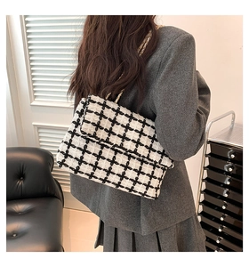 Détail du sac bandoulière en tweed pied-de-poule noir et blanc avec chaîne dorée