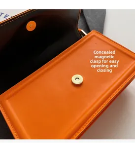 Detail view of the hidden magnetic closure and stitching on the orange leather handbag