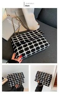 Détail du sac bandoulière en tweed noir et blanc avec chaîne en métal élégante