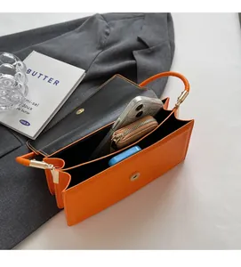 Interior view of orange leather handbag showing spacious capacity for phone and wallet