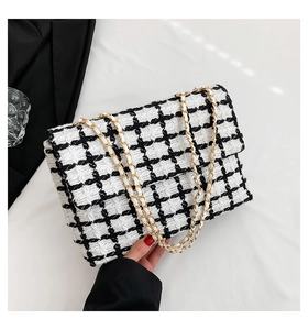 Détail du motif à carreaux en tweed noir et blanc et de la chaîne dorée sur le sac à main