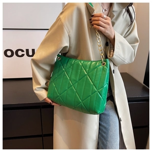 Detail view of vibrant green quilted PU leather shoulder bag with gold chain strap