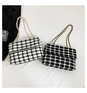 Détail de sacs à bandoulière en tweed à carreaux avec chaîne dorée en noir et blanc