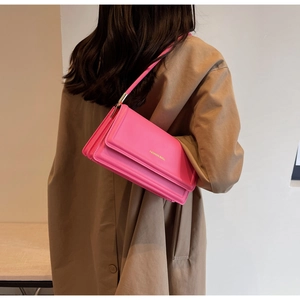 Fashionable bright pink shoulder bag styled with a brown trench coat for women