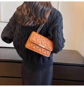 Brown quilted lattice square bag with gold chain strap shown on model's shoulder