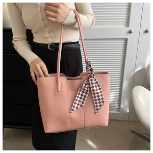 Close-up of pink tote bag with checkered scarf accent on shoulder of female model
