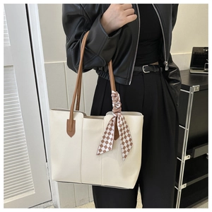 Detail of off-white PU leather tote bag with brown handles and checkered silk ribbon decoration