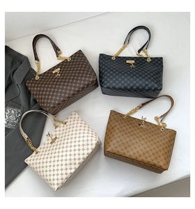 Detail showing four monogram tote bags in various colors with metallic deer pendant