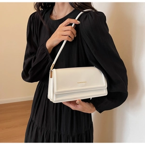 Close-up of a white rectangular crossbody bag featuring Fashion Bags gold lettering