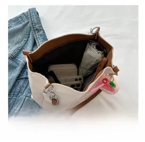 Top view of spacious interior of canvas tote bag with umbrella, wallet and phone