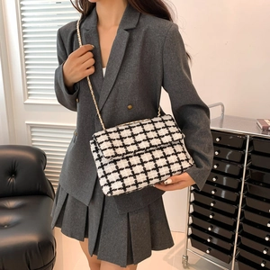 Sac bandoulière en tweed noir et blanc classique avec chaîne dorée sur modèle