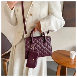 Quilted burgundy handbag with a matching mini coin purse and elegant gold hardware