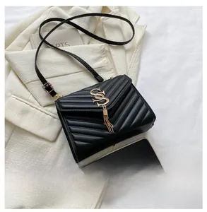 Detail of black quilted crossbody bag with gold hardware tassel and size comparison