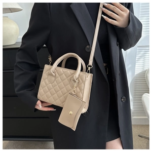 Detail of beige quilted satchel bag set with matching small pouch and adjustable strap