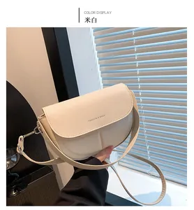 Dettaglio della borsa a sella bianco crema con scritta Fashion & Bags e patta liscia