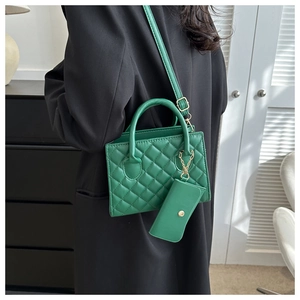 Detail of green quilted crossbody bag with matching mini pouch and gold hardware accents