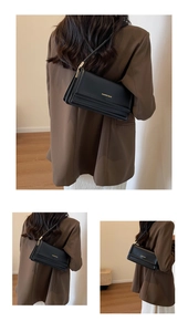 Three-way view of a classic black leather underarm bag with gold metal chain details