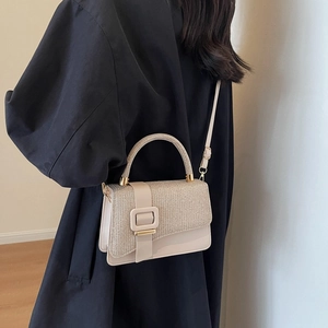 Elegant beige crossbody bag with gold thread stitching and smooth leather contrast