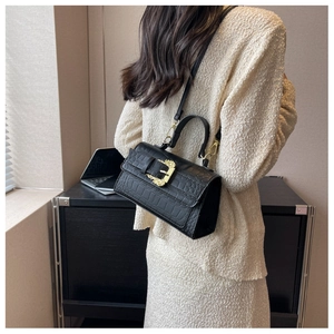 Model wearing black faux crocodile leather handbag with golden baroque style metal buckle