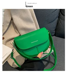 Vista dettagliata di una borsa a sella in pelle verde vivace con stampa bianca