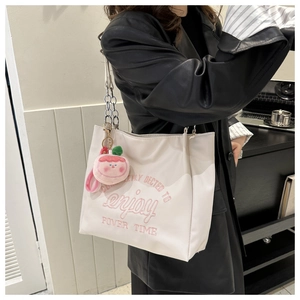 Detail of white nylon tote bag with pink 'enjoy' embroidery and metal chain strap