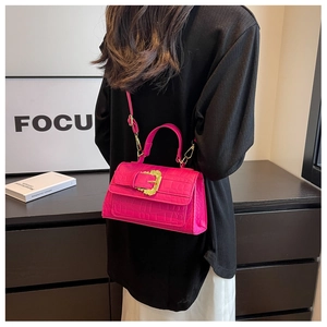 Close-up of rose red faux crocodile leather shoulder bag with golden baroque buckle