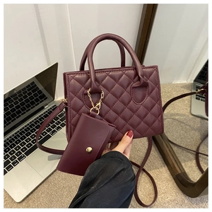 Detail of burgundy quilted handbag with matching mini coin purse and gold hardware