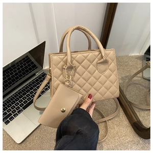 Detail of beige quilted handbag with matching coin purse and gold chain hardware