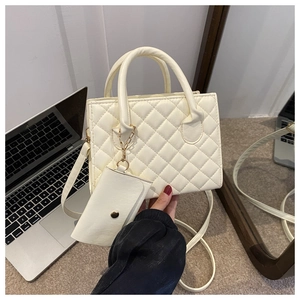 Detail of beige quilted handbag with matching coin purse and adjustable shoulder strap