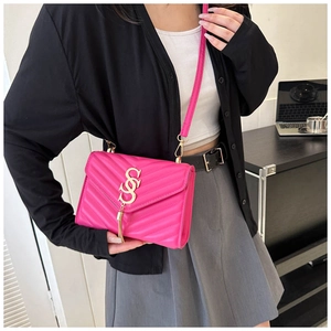 Detailed close-up of fuchsia quilted crossbody bag with gold tassel and V-pattern stitching