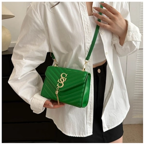 Detailed view of green quilted leather crossbody bag with gold V-logo and chain tassel