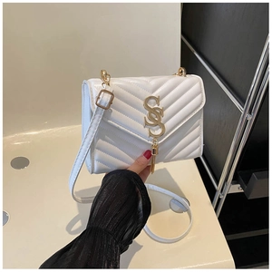 Detail of white V-quilted faux leather bag with gold metal hardware and tassel charm