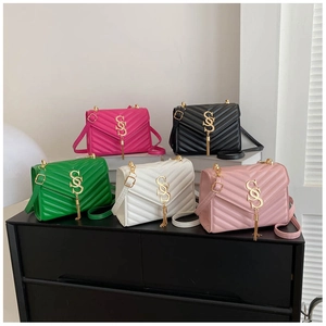 Close-up of quilted chain bags in various colors with gold logos and tassel details