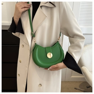 Detail of emerald green half-moon crossbody bag with polished gold round buckle