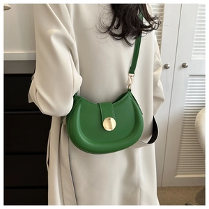 Green crescent saddle bag on a model showing size and fit with a gold buckle detail