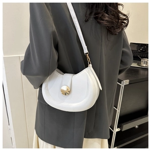 Close-up of white crescent saddle bag with gold metal buckle on female model